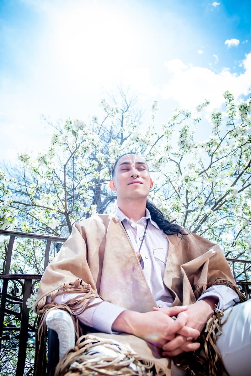 CBliss meditating outdoors with blossoms overhead